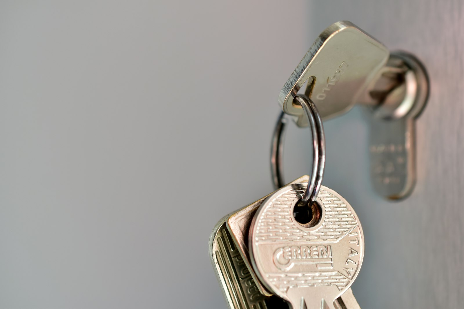 A bunch of keys hanging in a door lock